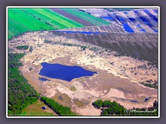 Am Moorlehrpfad Huvenhoopsmoor - Vorne der Moorlehrpfad mit dem Moorauge und im Hintergrund das Hochmoornaturschutzgebiet